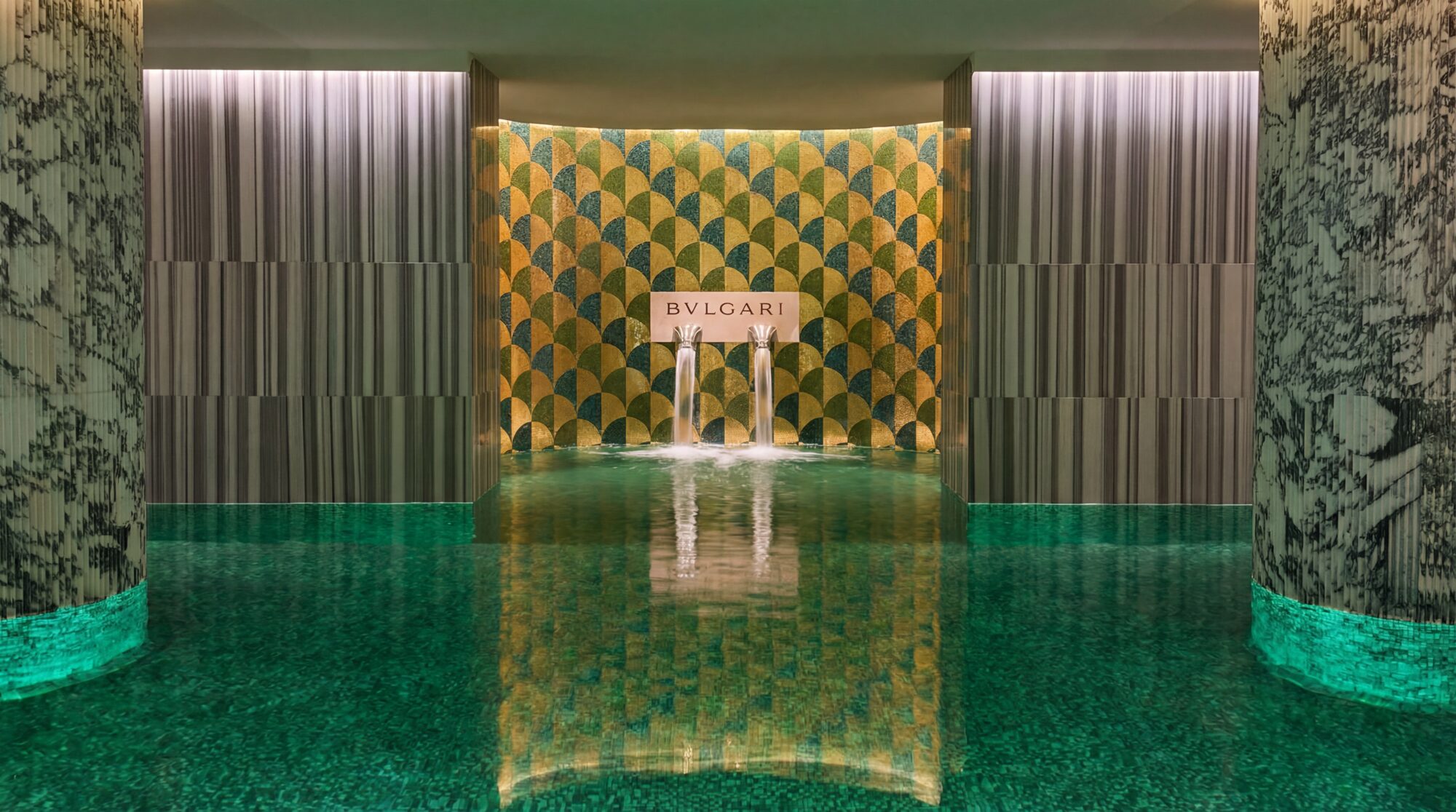 The mosaic pool of Bvlgari Hotel Roma — twin fountains under the gold and green scaled mosaic wall