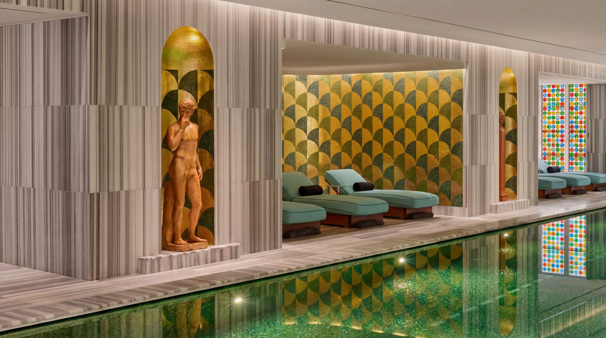 A gilded statue in its niche beside the emerald pool at Bvlgari Hotel Roma's spa