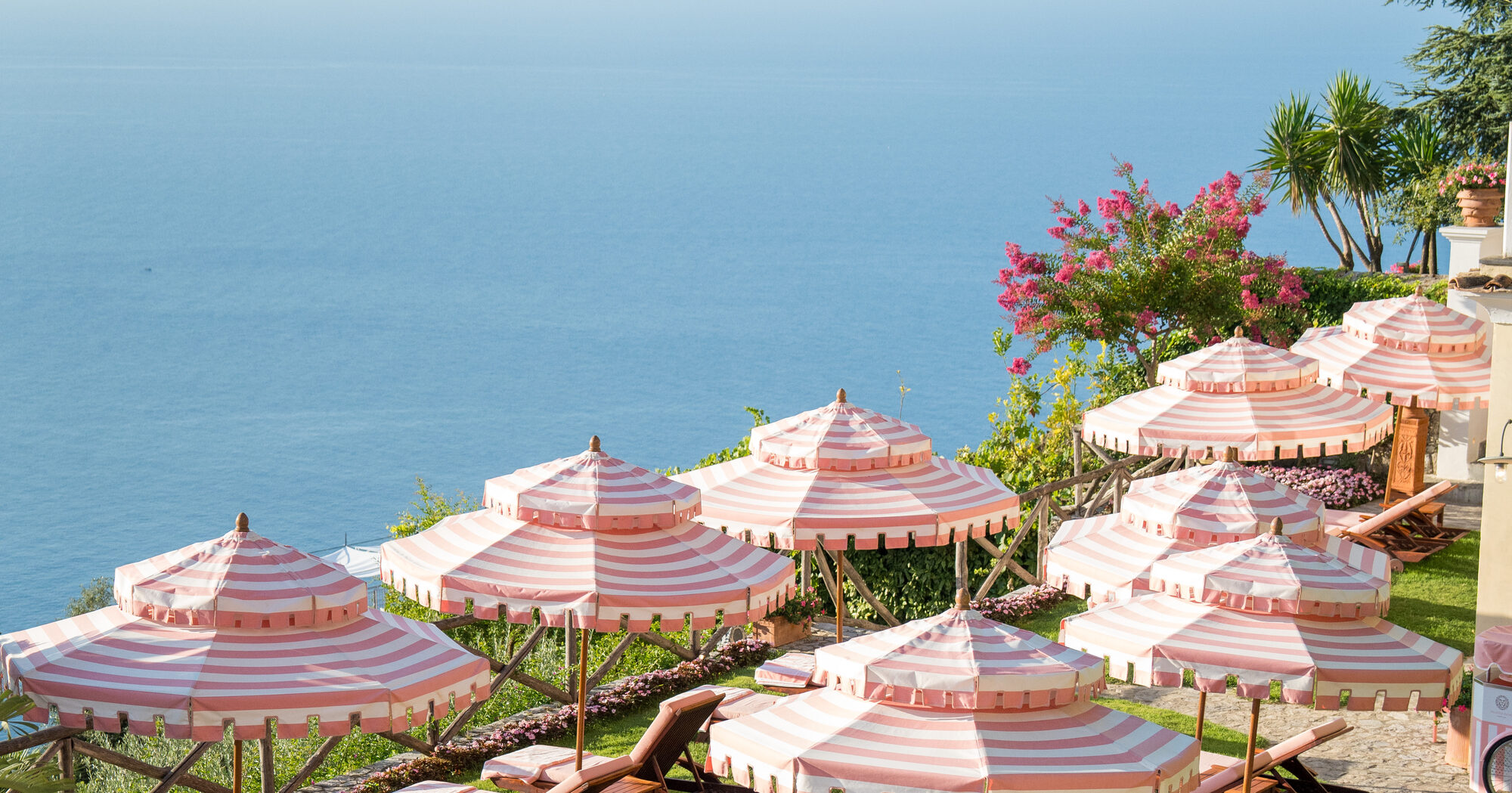 Pink-striped parasols on the lawn of Palazzo Avino, suspended above the Tyrrhenian sea