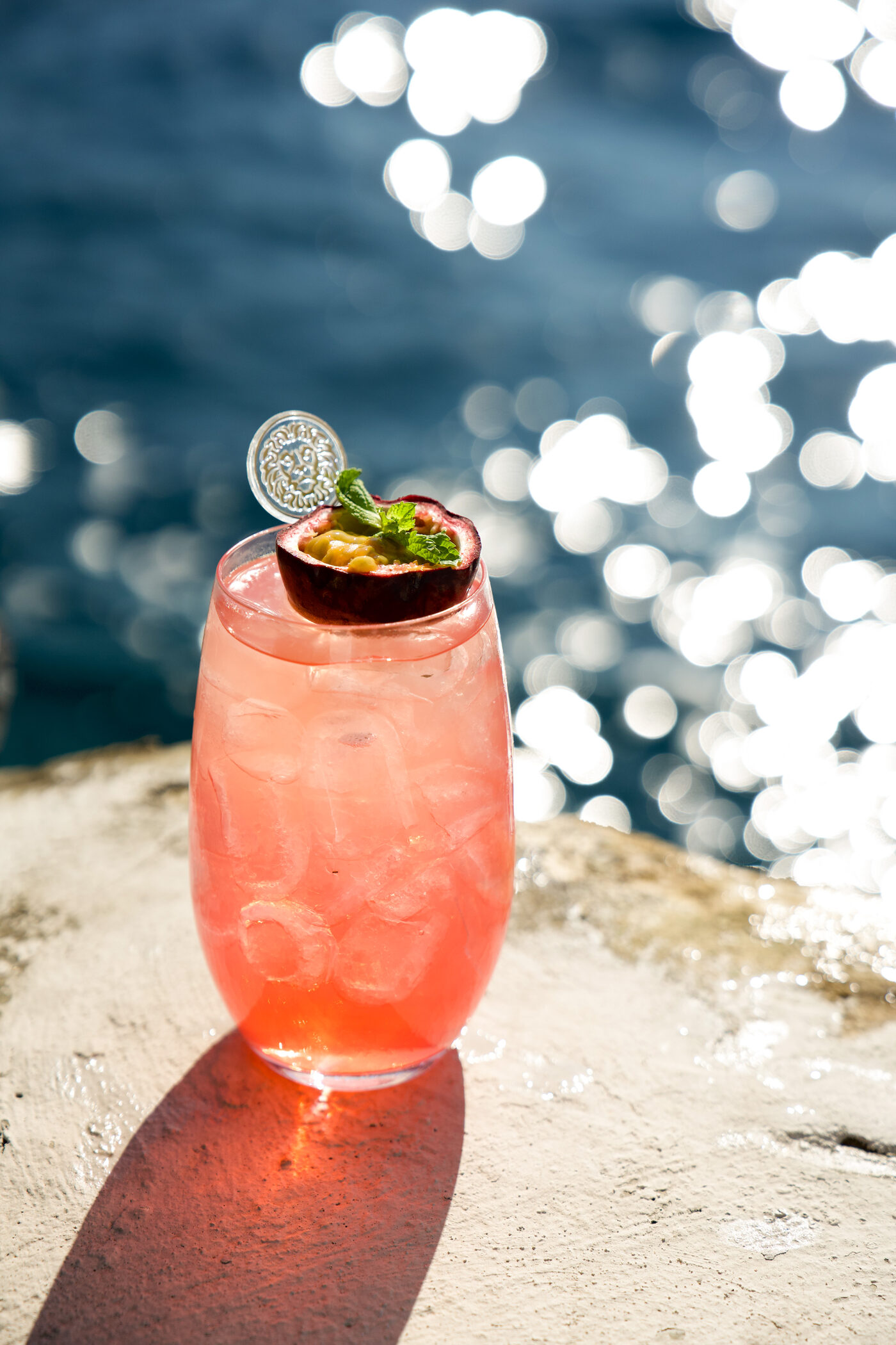 A rose cocktail on warm stone against the sparkling sea, Palazzo Avino