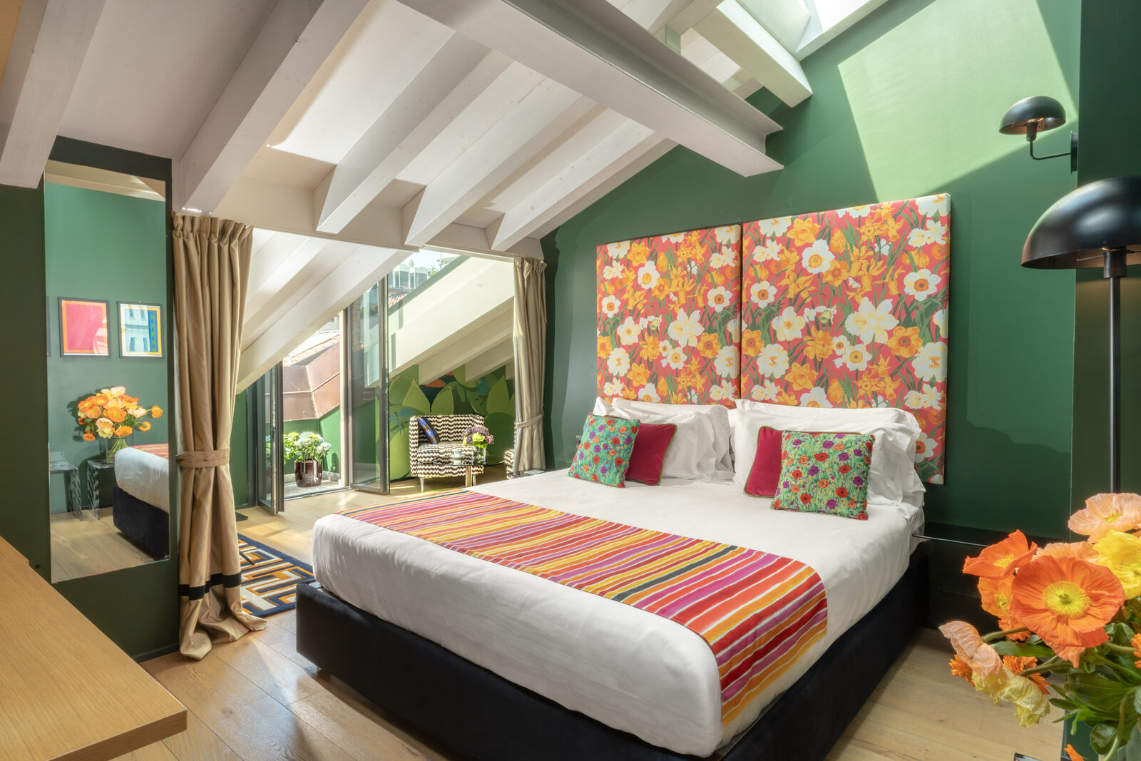 A bedroom at Speronari Suites with mirrored wardrobe and flowers by the window, Milano